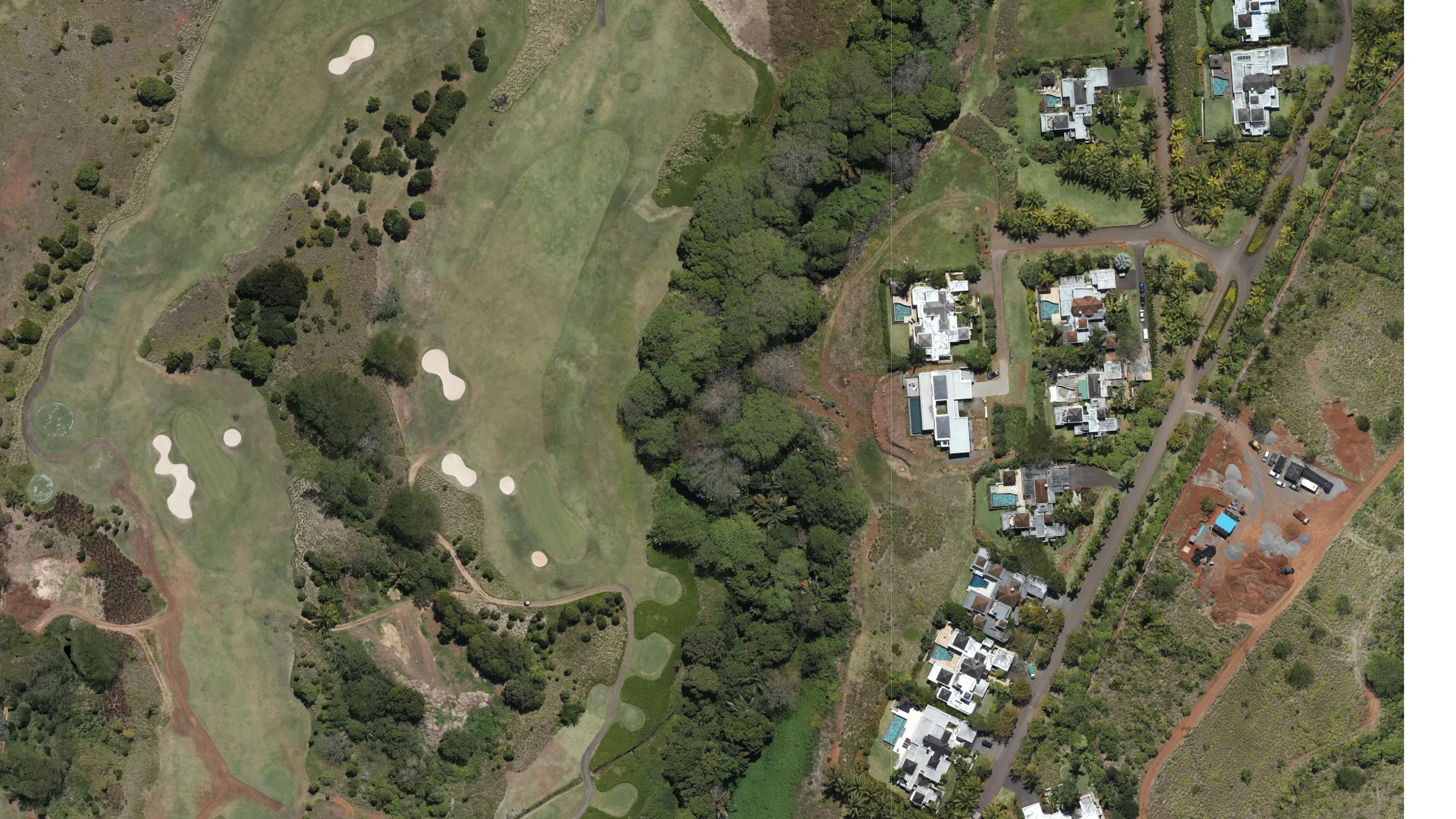 True-colour aerial orthomosaic of a golf course and neighbouring residential development, seamless and north-up, resolving individual trees, bunkers, swimming pools, parked vehicles and footpaths